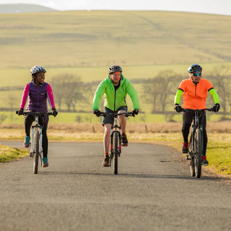 Three cyclists riding in England on a cycling holiday